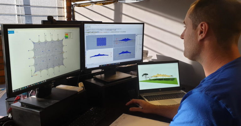 Designer examining engineered tent patterns and three-dimensional tent models on two monitors