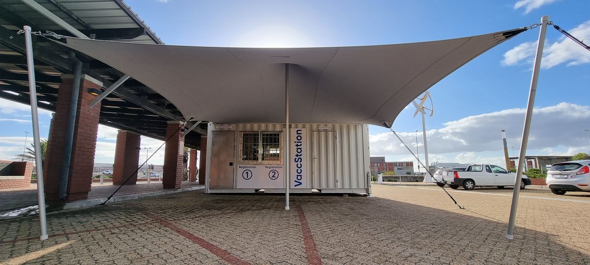 White custom stretch canopy sheltering the entrance to a converted shipping container