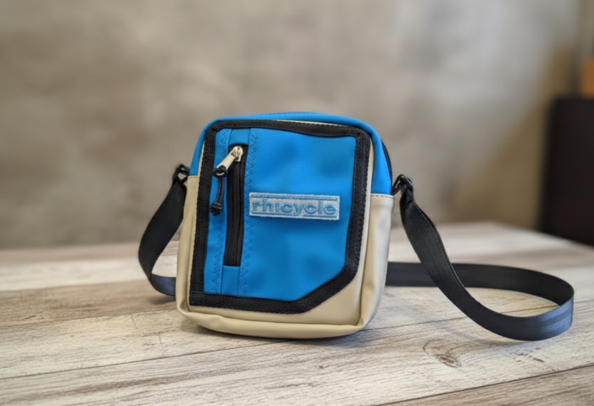 Product image showing a compact blue and beige shoulder bag created from recovered RHI stretch tent material