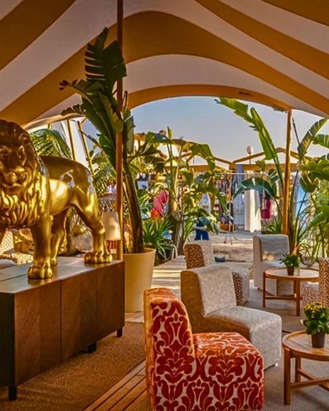 Decorated restaurant lounge beneath a Custom Chino and White Striped Restaurant Stretch Tent in a Luxury Spanish Commercial Venue