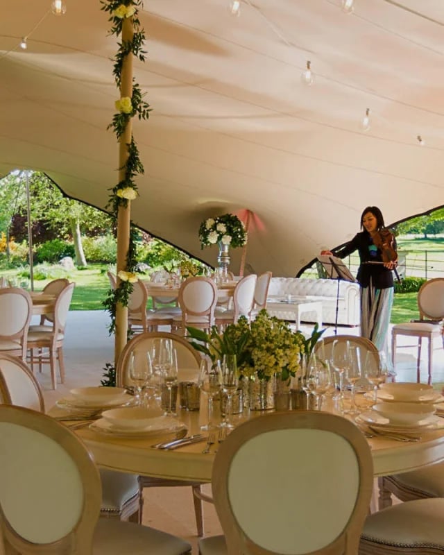 Wedding dining area inside a white RHI stretch tent with floral styling