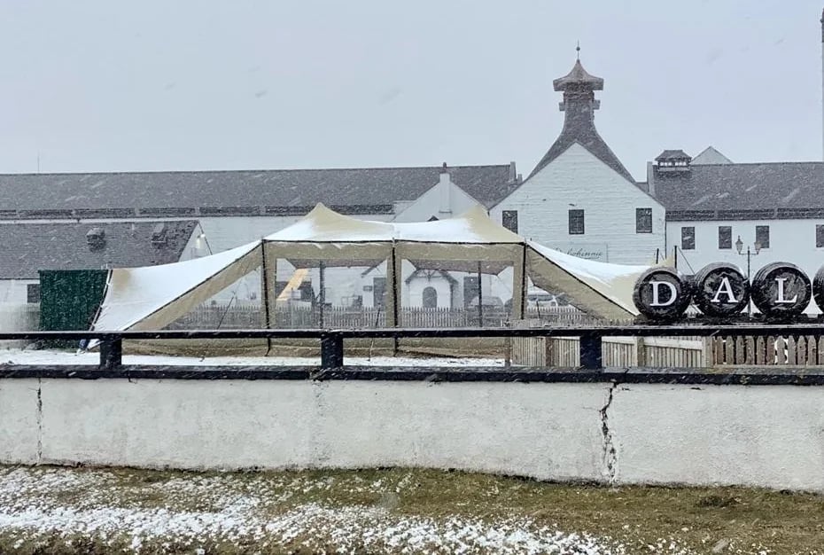 Corners-down stretch tent with modular walling during snowfall