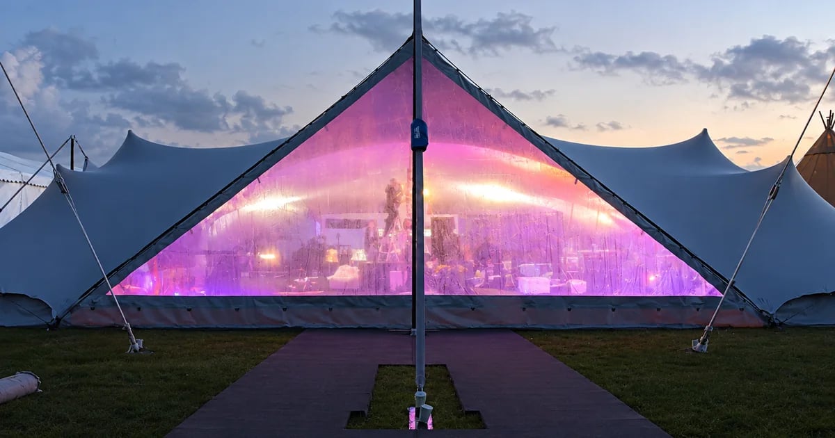 Clear RHI stretch tent walling and door system illuminated at dusk