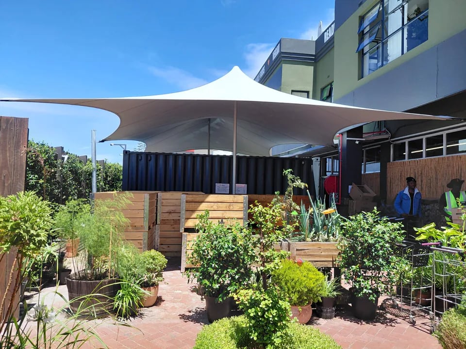 RHI White custom stretch canopy integrated into a landscaped courtyard