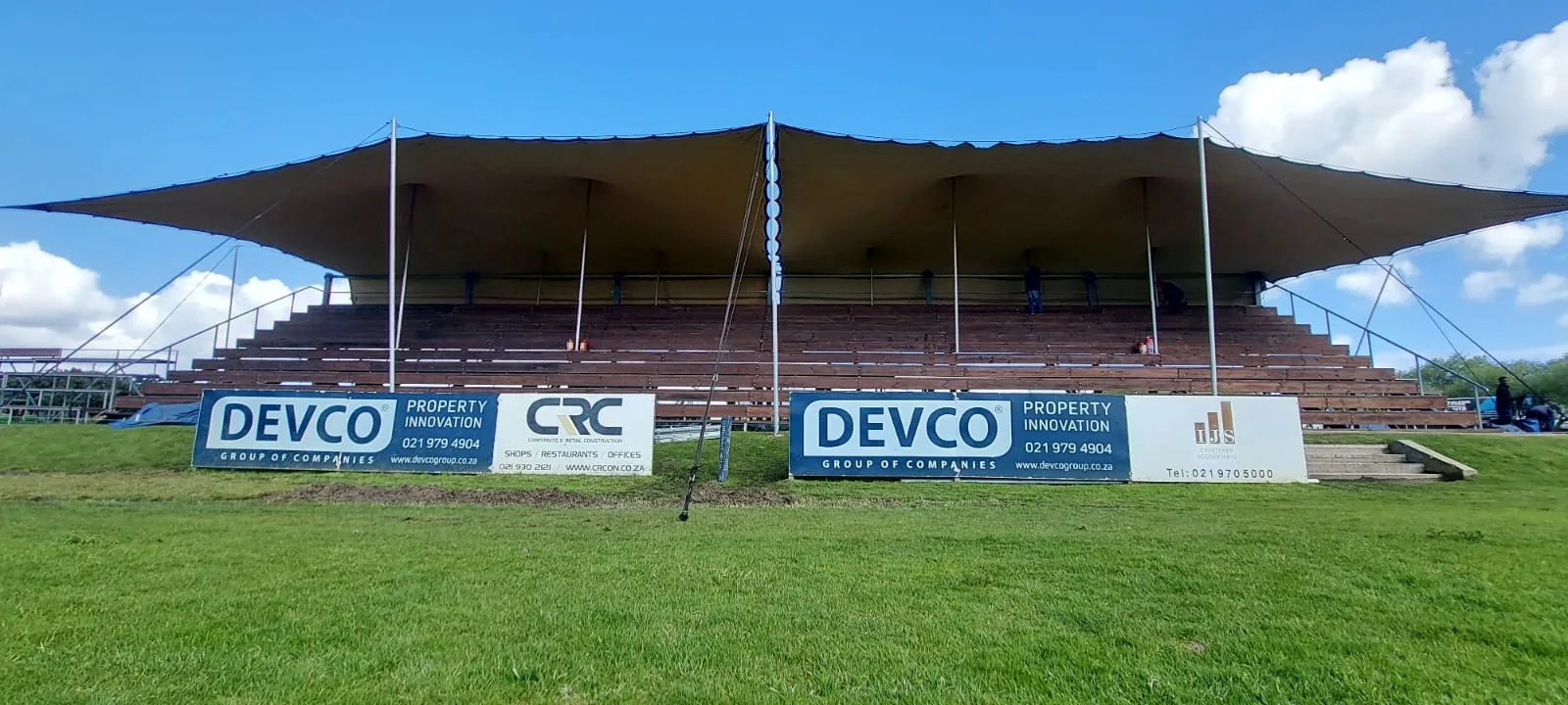 Linked stretch tents providing covered seating at a sports event