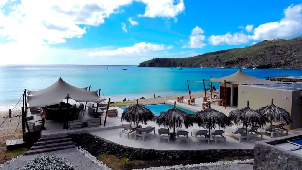 Beachfront resort with stretch tent terraces beside a pool — Beachfront Stretch Tents at Chatham Bay in the Grenadines
