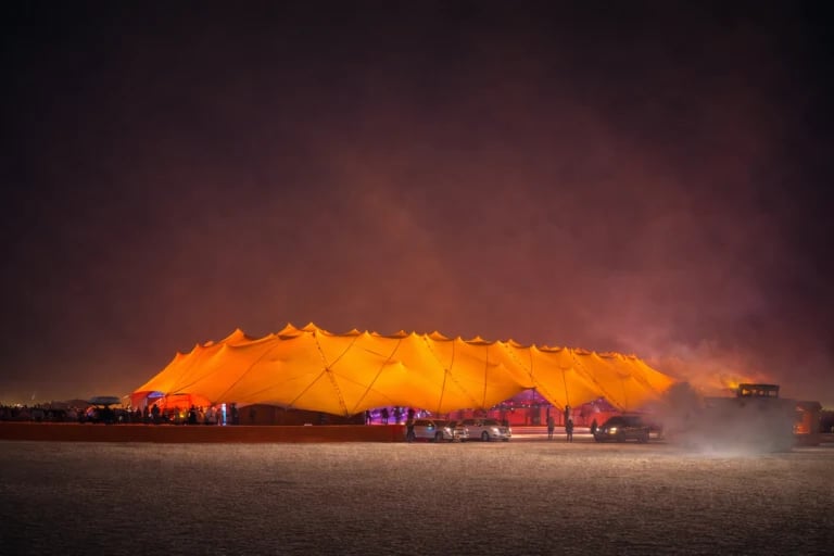 Large multi-peak pavilion illuminated in amber at night — 40 × 80 m Stretch Tent for a Corporate Event in Doha