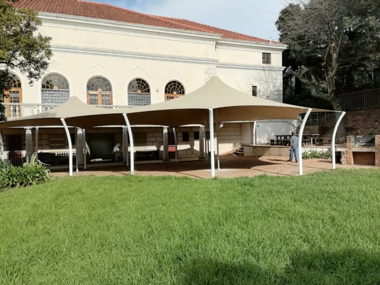 Light stretch tent and curved white supports in a paved courtyard — Courtyard Stretch Tent at Groote Schuur Hospital