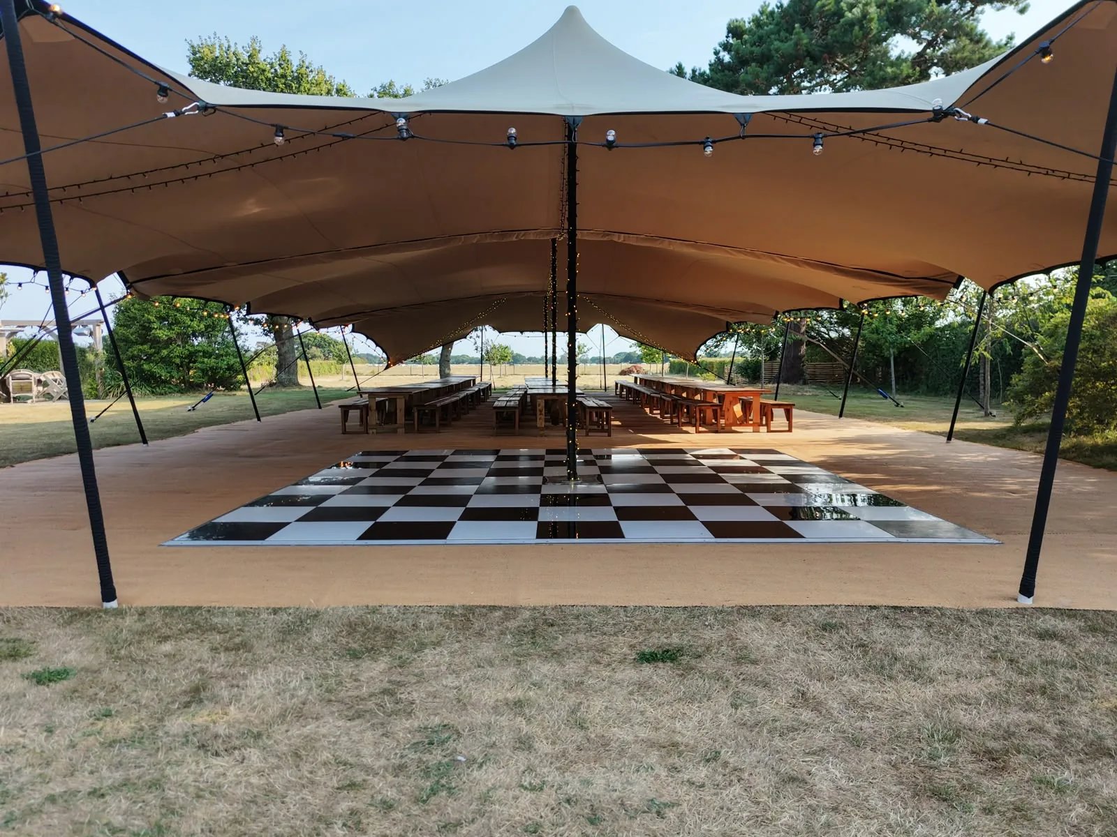 Covered event space beneath three linked stretch tents