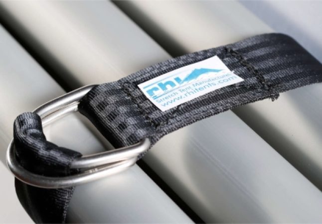 Close-up van een zwarte stoffen bevestigingslus en een metalen ring op de aluminium tentstokken van RHI