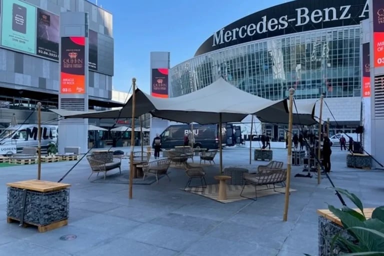 Vue depuis la place située en face d'une installation « tente stretch » blanche de taille moyenne de la marque RHI, installée sur une place publique à l'extérieur de la Mercedes-Benz Arena