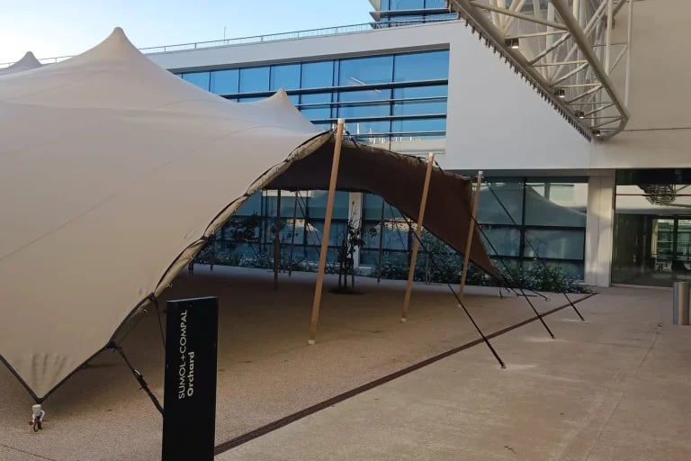 Vue depuis l'entrée, à côté d'un lieu événementiel moderne en Espagne, d'une grande « tente stretch » de RHI aménagée pour accueillir des événements d'entreprise
