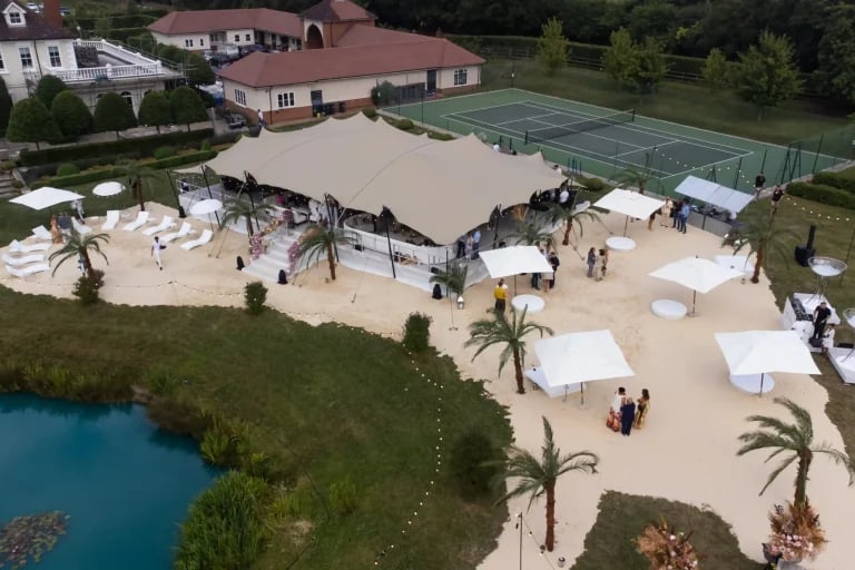 Vue aérienne, près d'une plage britannique, d'une installation RHI tente stretch équipée d'un salon et de sièges destinés à l'accueil des visiteurs