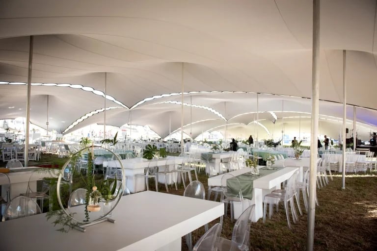 Vaste espace de restauration aménagé sous des auvents reliés entre eux, à l'intérieur d'un « RHI » blanc tente stretch , aménagé pour un événement d'entreprise