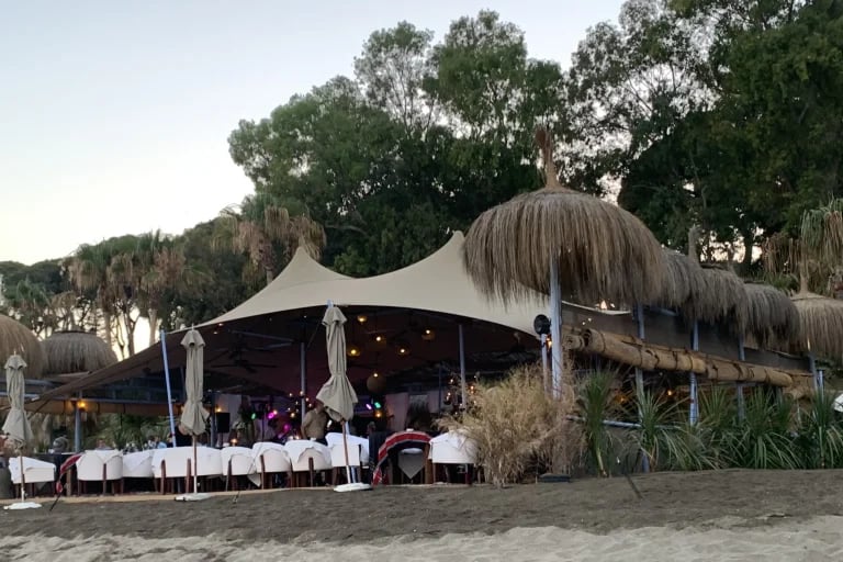 Vista nocturna del restaurante de un « Carpa Tensada » de RHI hecho a medida en España, integrado en un restaurante frente al mar