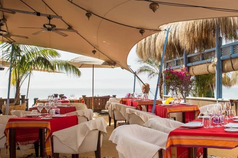 Vista del interior del comedor de una chimenea RHI « Carpa Tensada », fabricada a medida e integrada en un restaurante frente al mar en España