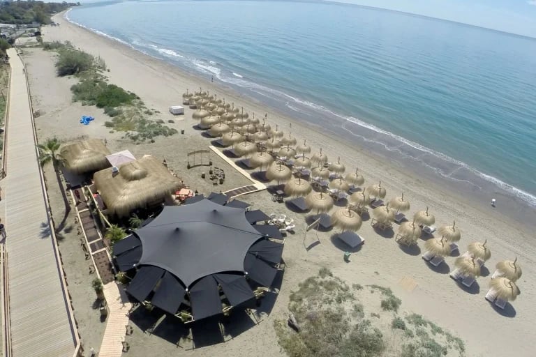 Vista aérea del RHI « Carpa Tensada » negro y personalizado, integrado en un restaurante frente al mar
