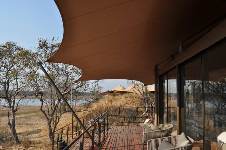 Vista detallada desde la terraza del albergue de una tienda de glamping RHI Carpa Tensada hecha a medida e integrada en un campamento ecológico aislado