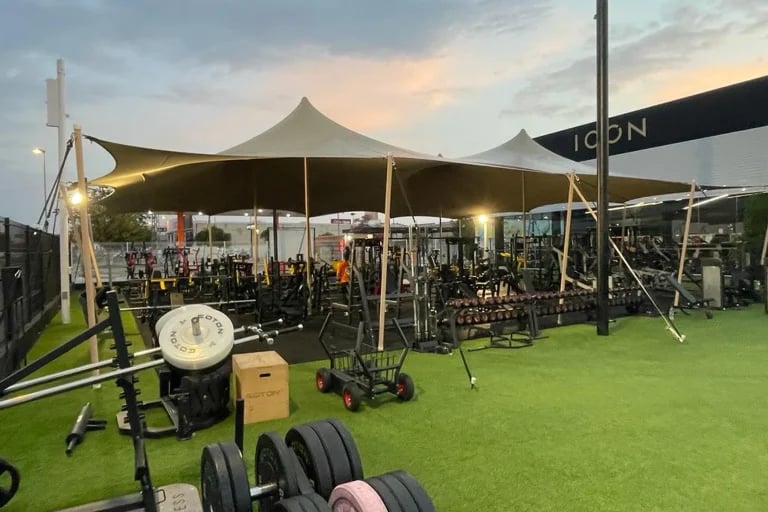 Vista frontal nocturna de una cubierta « Carpa Tensada » de RHI, fabricada a medida, que cubre un gimnasio al aire libre y una zona de entrenamiento en España