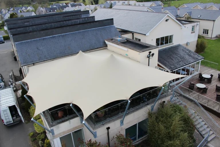 Vista aérea de una cubierta « Carpa Tensada » de RHI, fabricada a medida en tela chino, que cubre la terraza del restaurante de un campo de golf en Irlanda