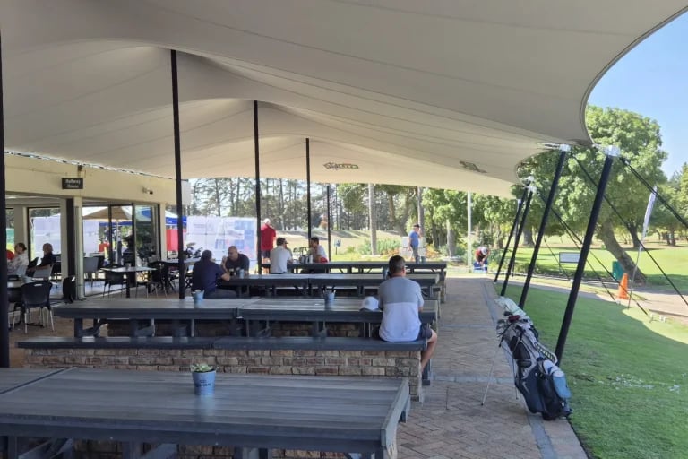 Vista a lo largo del borde catenario de una cubierta « Carpa Tensada » de RHI, fabricada a medida, que cubre la zona de gradas y de restauración de un campo de golf.