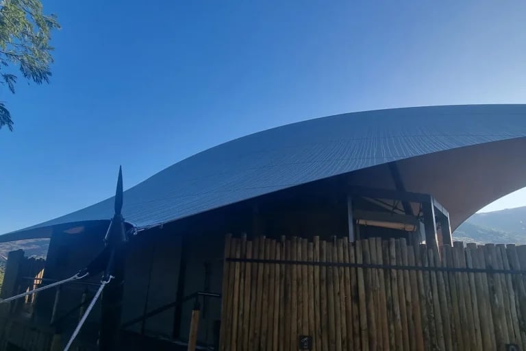 Vista exterior de un toldo extensible RHI hecho a medida, integrado en un campamento de tiendas de lujo