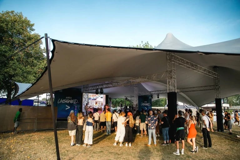 Vista de la entrada al escenario de una estructura de vigas y un « Carpa Tensada » de RHI fabricados a medida, utilizados en un festival público en el Reino Unido