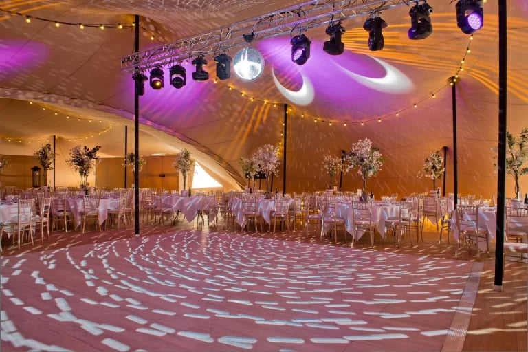Vista de la pista de baile y la iluminación del interior de un RHI « Carpa Tensada » a medida, de gran escala y de diseño modular, decorado para una cena formal en el Reino Unido.