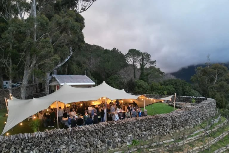 Vue prise en soirée, depuis une colline, d'un système RHI tente stretch servant de couverture lors d'un événement public ou privé en plein air