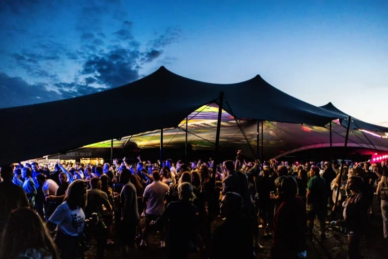 Vue d'ensemble de l'extérieur d'un grand abri noir de type « RHI » ( tente stretch ) abritant les festivaliers au Royaume-Uni