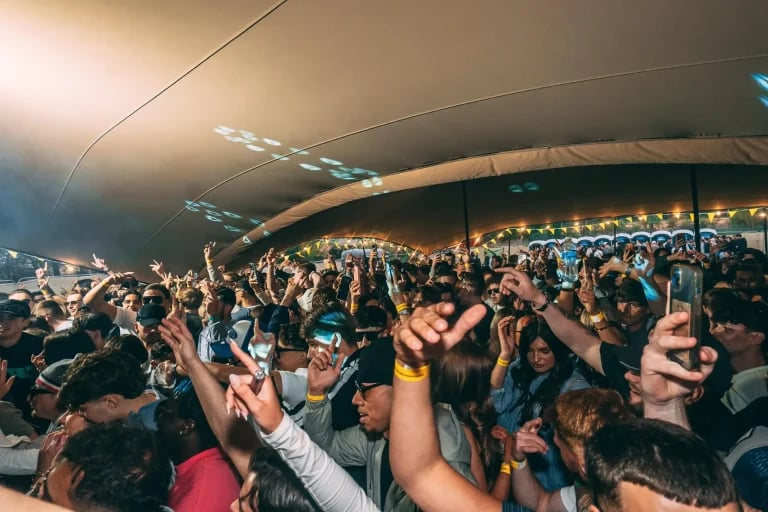 Plan d'ensemble montrant la foule d'un festival sous un immense écran « RHI » tente stretch , avec l'éclairage de la scène