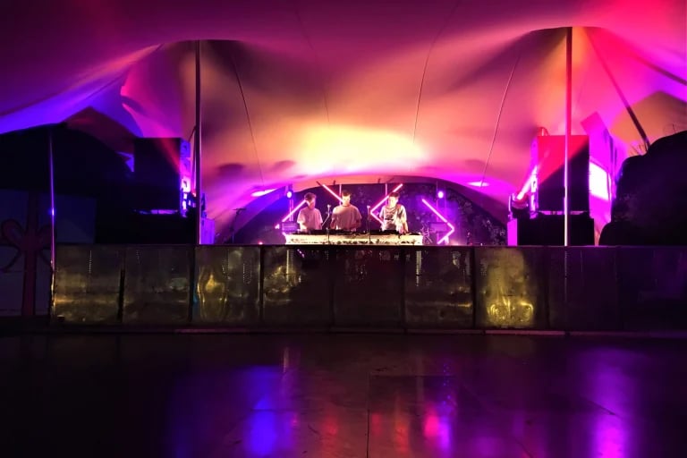 Scène de spectacle illuminée au sein d'un grand tente stretch du festival RHI aux Pays-Bas