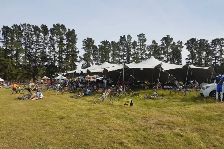 Vue d'ensemble extérieure d'une grande installation RHI « tentes stretch » à modules interconnectés, mise en place à l'occasion d'un événement cycliste en plein air très fréquenté en Europe
