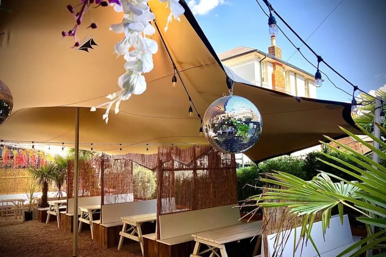 tente stretch s RHI permanentes en Europe, couvrant une terrasse extérieure aménagée pour l'accueil de clients