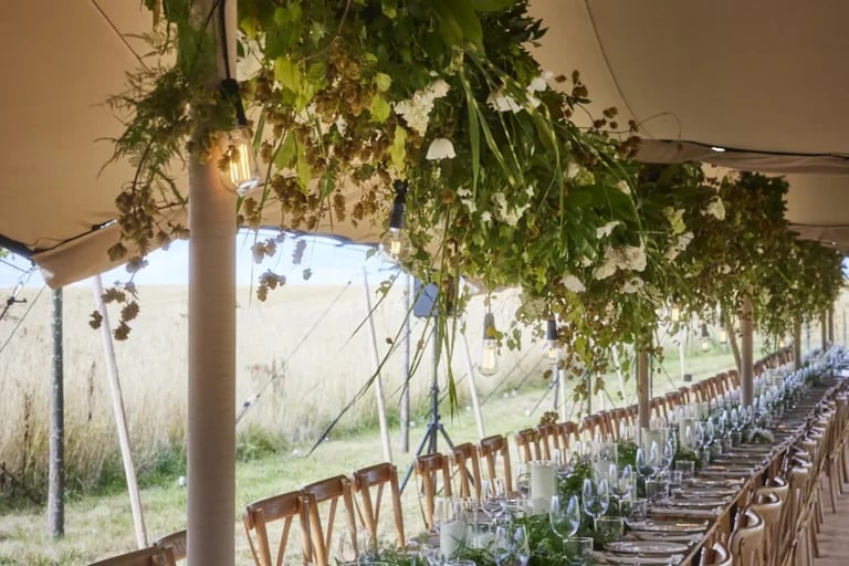 Intérieur avec une longue table de banquet de l'événement « RHI European Wedding » tente stretch, aménagé pour les mariages et les réceptions privées