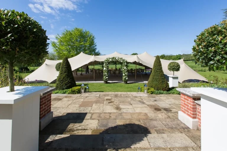 Vue de l'entrée d'un jardin à l'anglaise d'une propriété « RHI » tente stretch aux Pays-Bas, aménagée pour un mariage ou une réception en plein air
